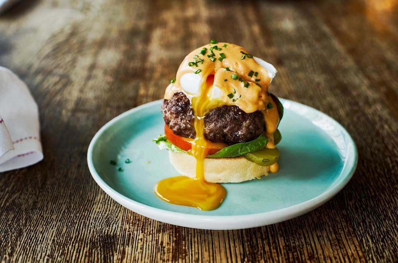 Beautifully presented open burger with an oozing poached egg placed on top