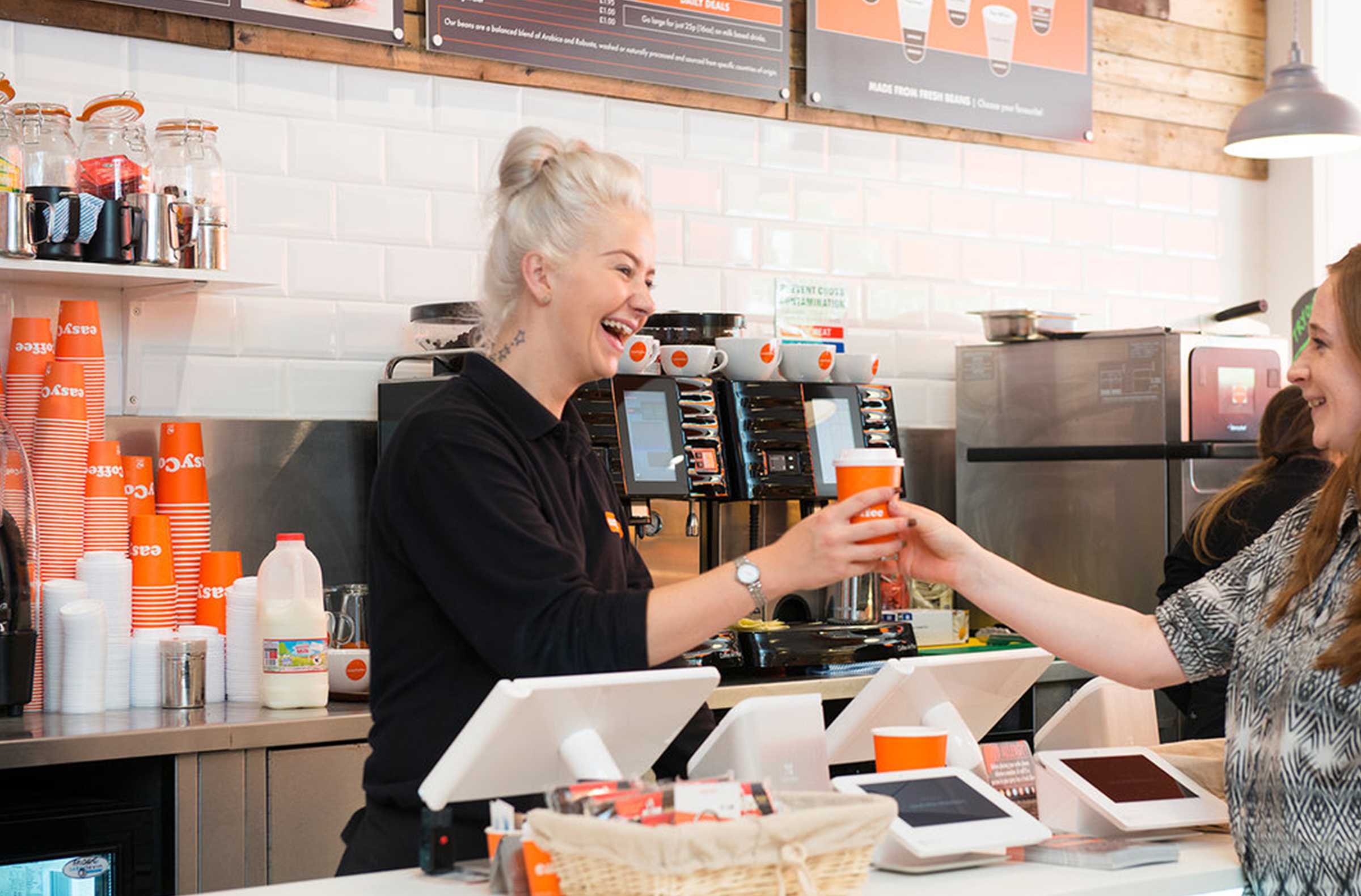 Barista handing a coffee to a customer